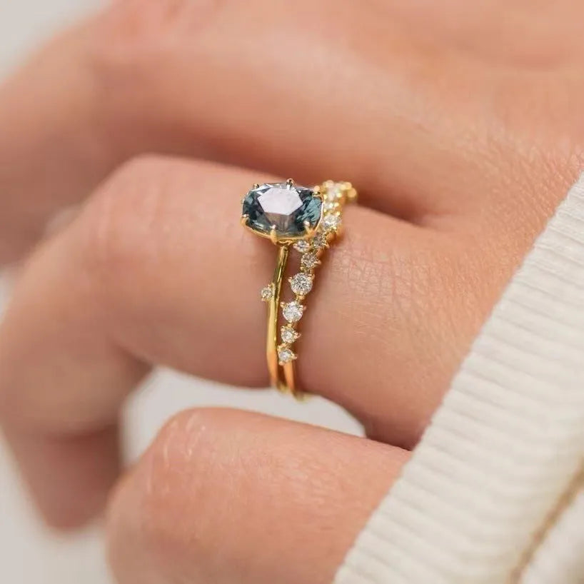 Gold electroplated alloy flower-shaped ring with inlaid green zircon stones on a white background.