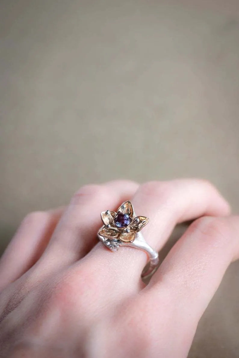 Silver-tone alloy women's ring with geometric shape and two-tone floral design on a white background.