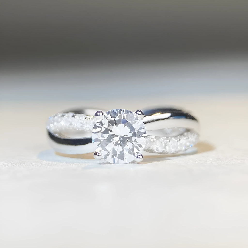 Geometric cross moissanite ring with winding twisted silver arms and four-claw setting