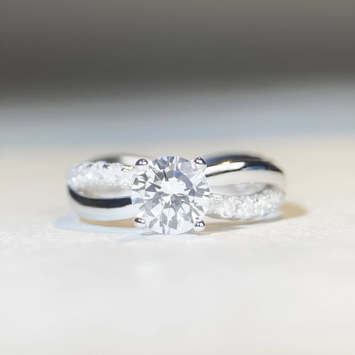 Geometric cross moissanite ring with winding twisted silver arms and four-claw setting