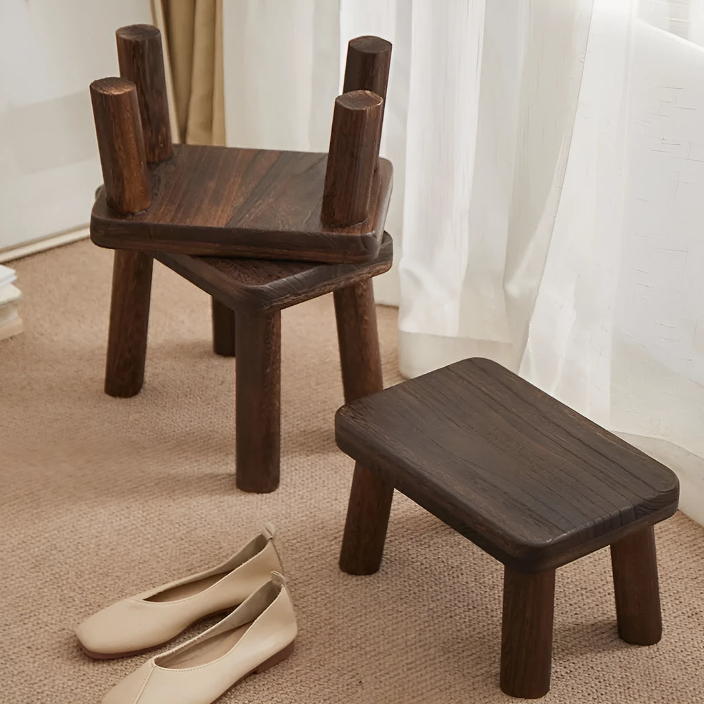 Rustic distressed wooden changing stool with bracket structure for shoe removal.