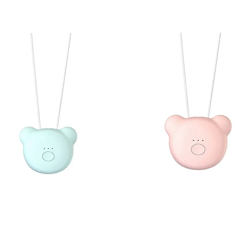 Small pink USB portable air purifier necklace on a table with charging cable.