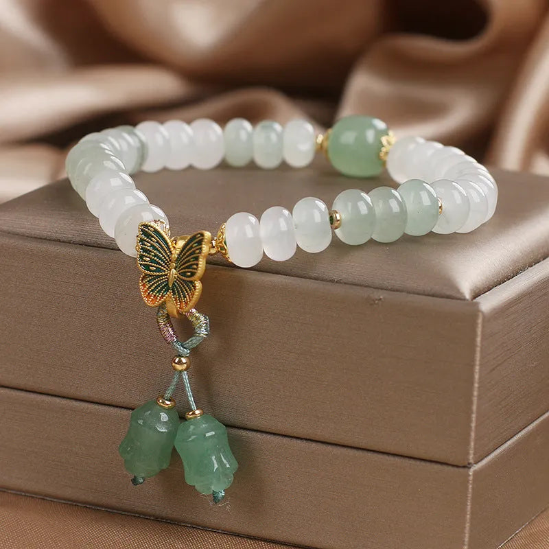 Green crystal abacus bead bracelet with retro butterfly tassel and pearl accents on a 17cm chain.