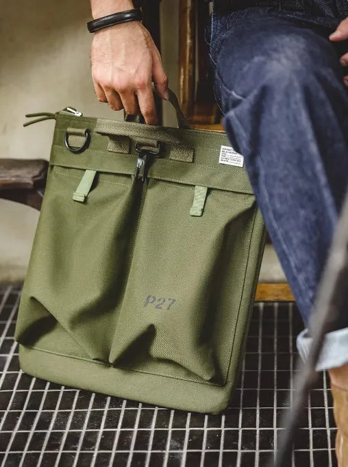 Canvas crossbody messenger bag in military green with shoulder strap showing vertical square shape and zipper closure