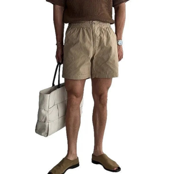 Men's loose-fit cotton sports shorts in black, shown on a hanger.