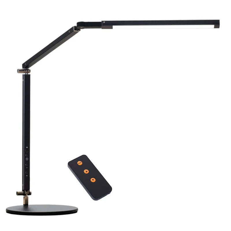 Folding aluminium desk lamp with a metal clip, shown in dazzling black, attached to a desk edge.