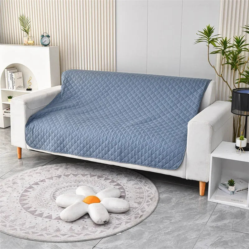 Reversible waterproof dog blanket laid flat on a sofa, showing two colour options.