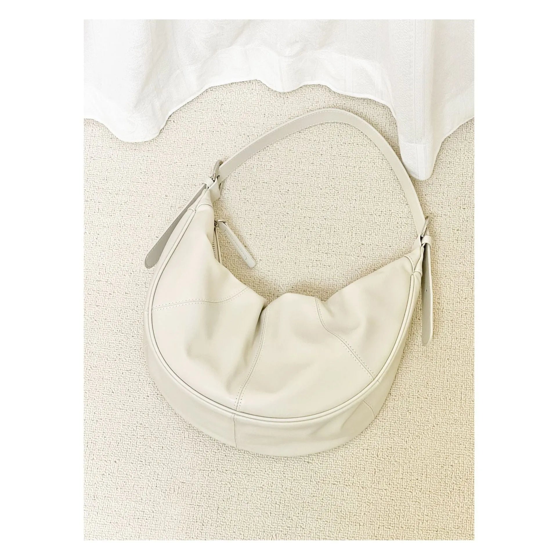 Women's soft cowhide leather dumpling-shaped shoulder bag in black with double straps and sandwich pockets.