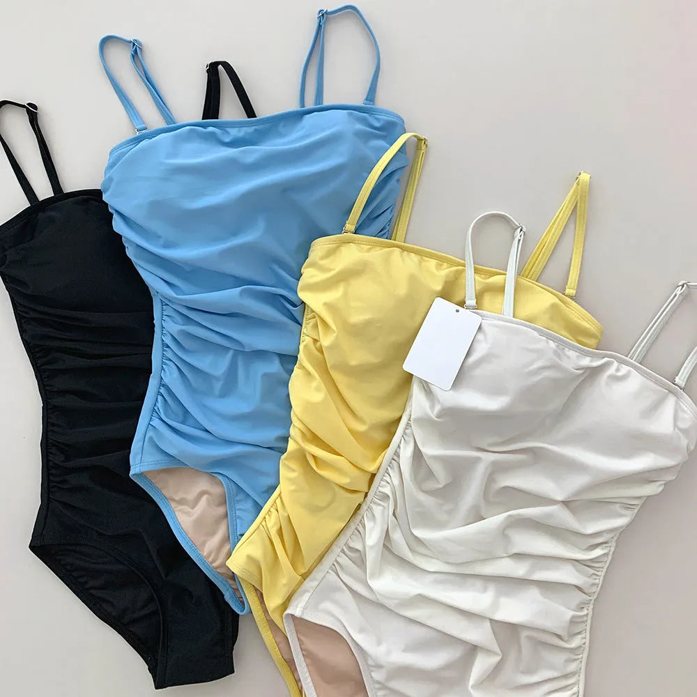 Women's sling style one-piece swimsuit with belly pleats in solid colour options