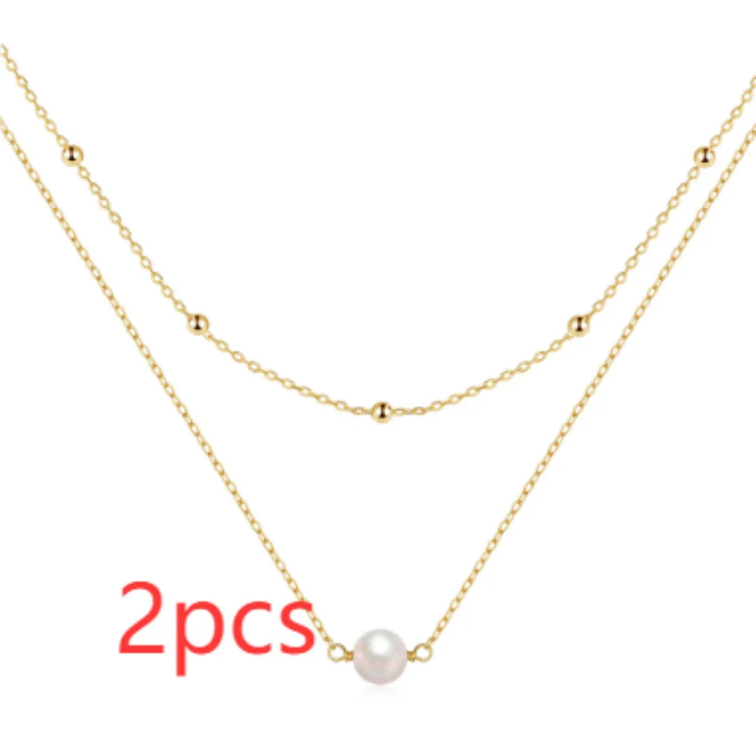 S925 sterling silver double layer necklace with twin pearls on a geometric pendant, shown in gold and white gold finishes.