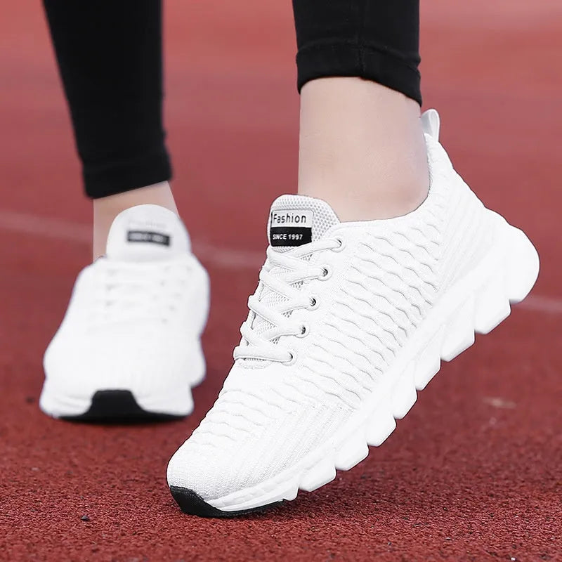Women's running shoes in black, pink, or white with a breathable fly weave upper and wear-resistant outsole.