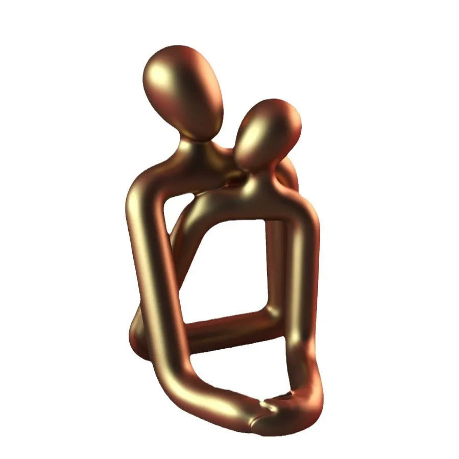 Modern resin statue of an embracing couple in milky white or gold finish on a wooden surface.