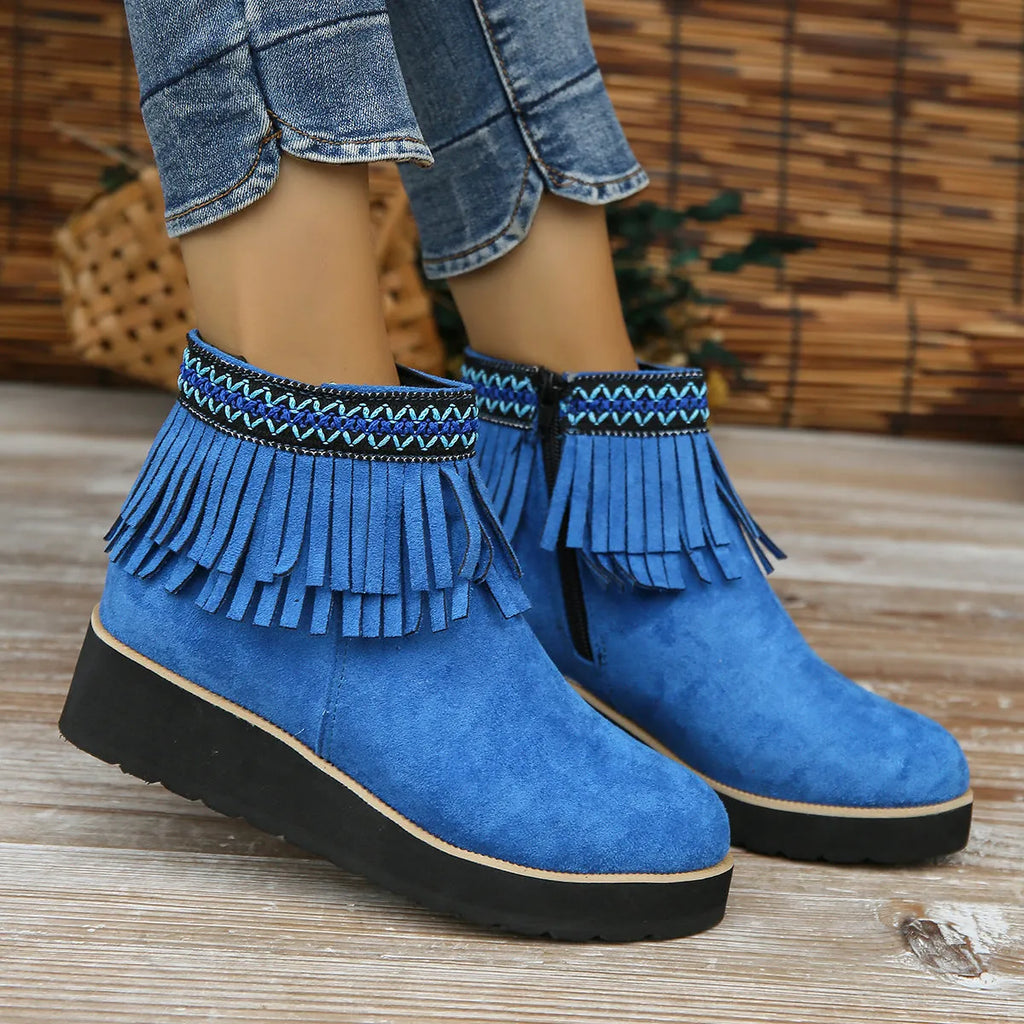 Women's suede ankle boot with wedge heel, side zipper, and tassel detail in dark brown.