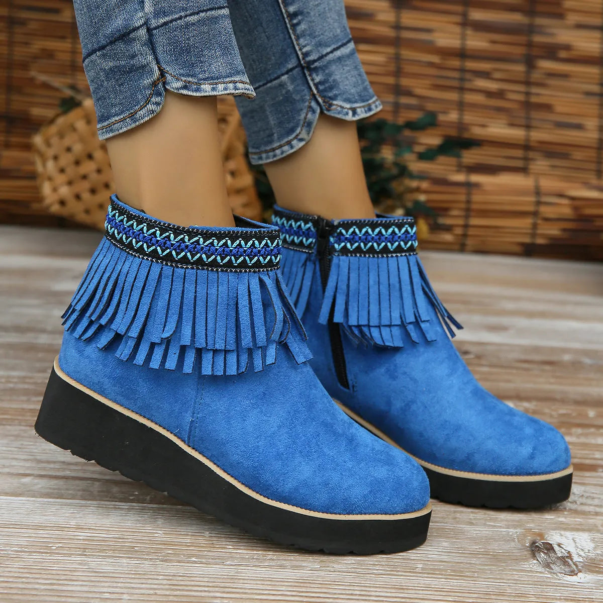 Women's suede ankle boot with wedge heel, side zipper, and tassel detail in dark brown.