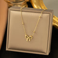 Gold titanium steel bow necklace on cross chain, adjustable 41-50 cm, for women's fashion