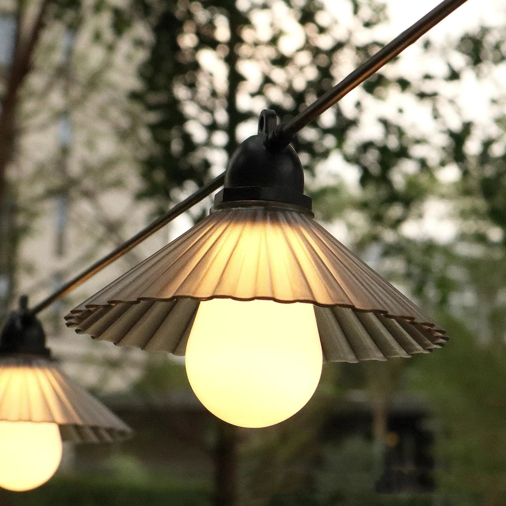 Outdoor LED string lights with flower-shaped bulbs in warm white and colour options.