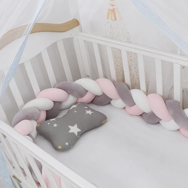 Bendable braid-knot baby crib bumper in spandex velvet, shown in a light grey colour wrapped around a cot.
