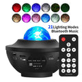 Black parallel style starry sky projection lamp with Bluetooth and rotating water ripple laser effects on a desktop.
