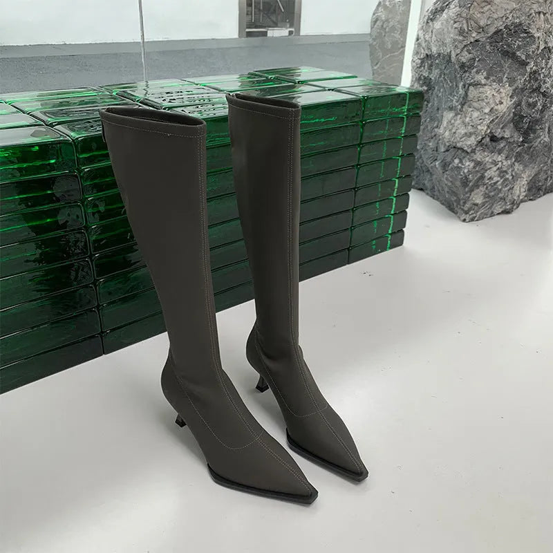 Women's black pointed toe stiletto heel boots with a back zip, shown from the side.