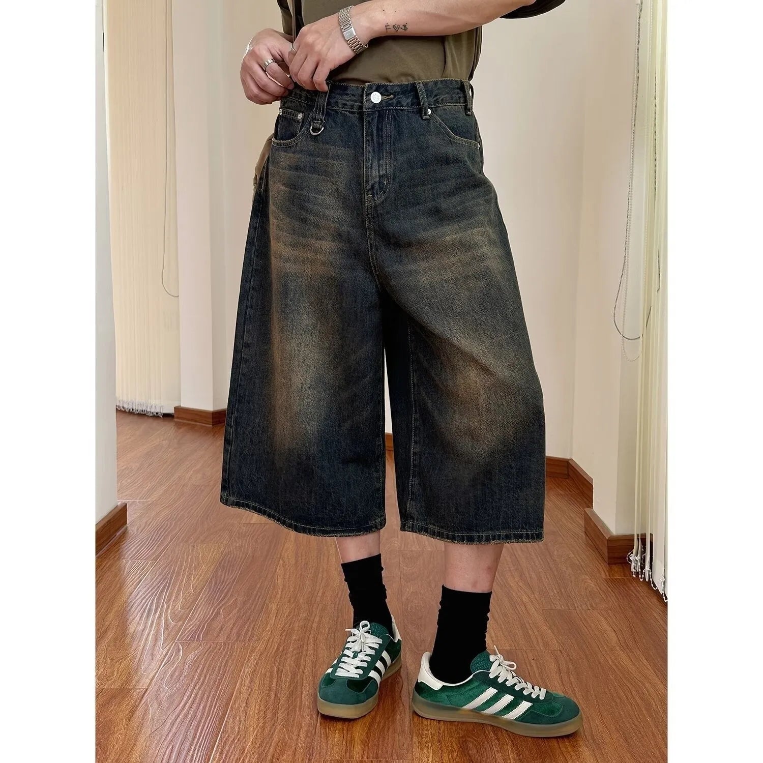 Men's straight-leg loose fit denim shorts in light blue on a neutral background.