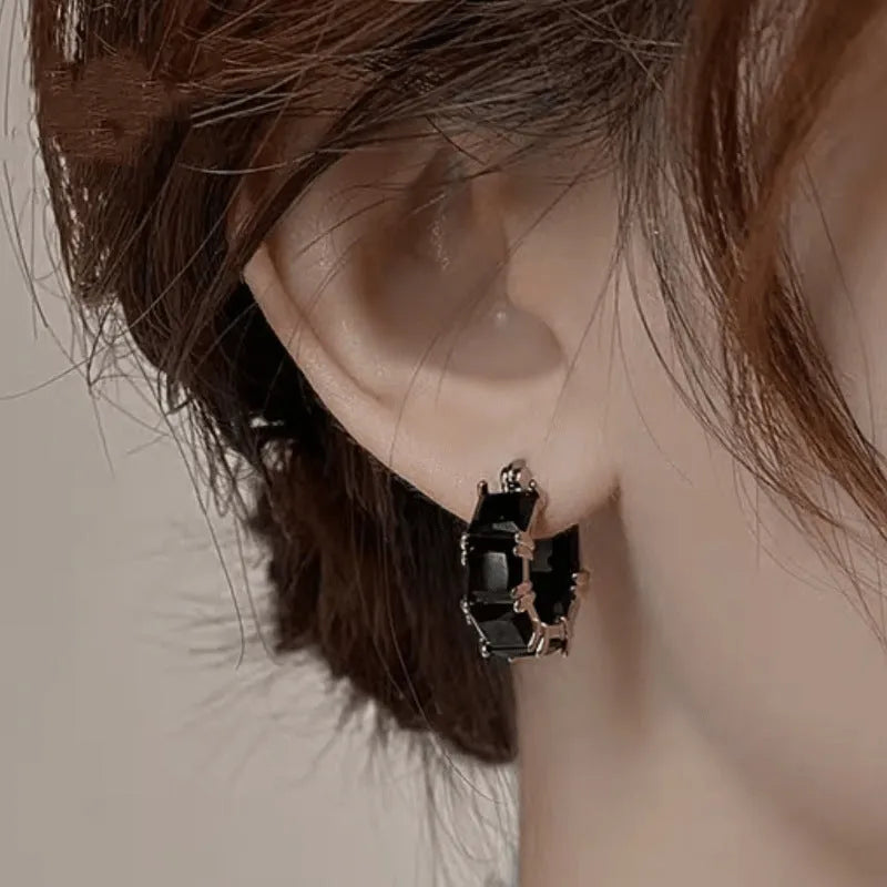Geometric U-shaped gold earrings with round accents and black zircon stones
