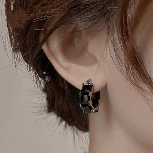 Geometric U-shaped gold earrings with round accents and black zircon stones