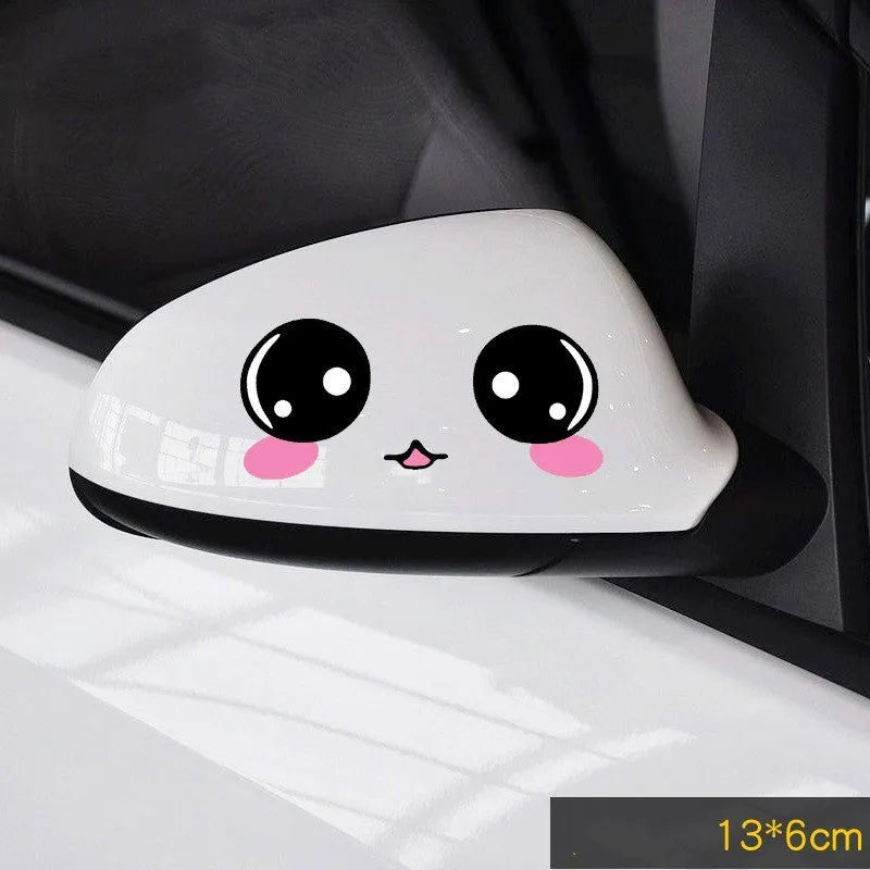 A pair of reflective cartoon eye car stickers on a vehicle rearview mirror.
