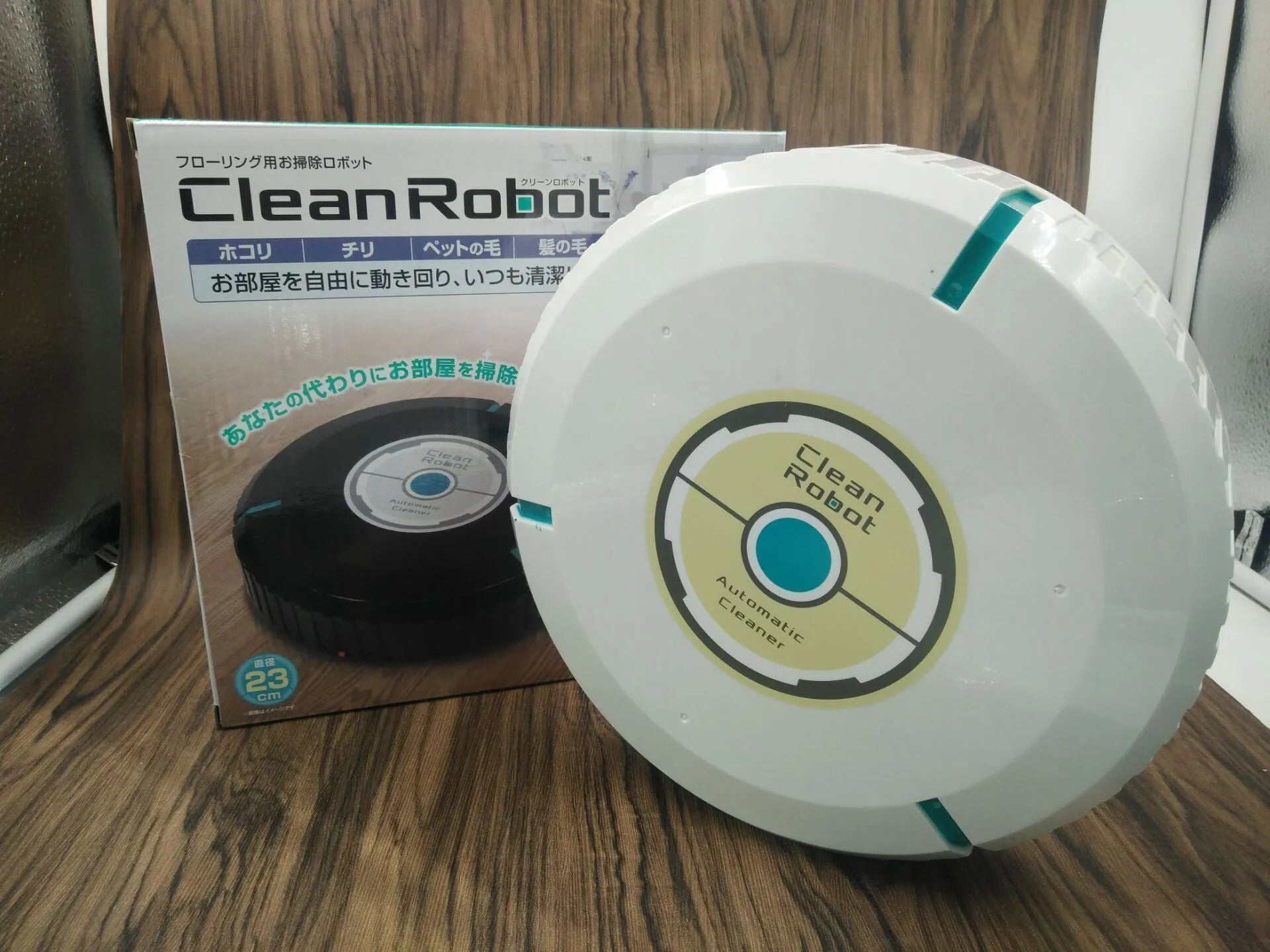 AC automatic sweeping robot on wooden floor with black ABS plastic body