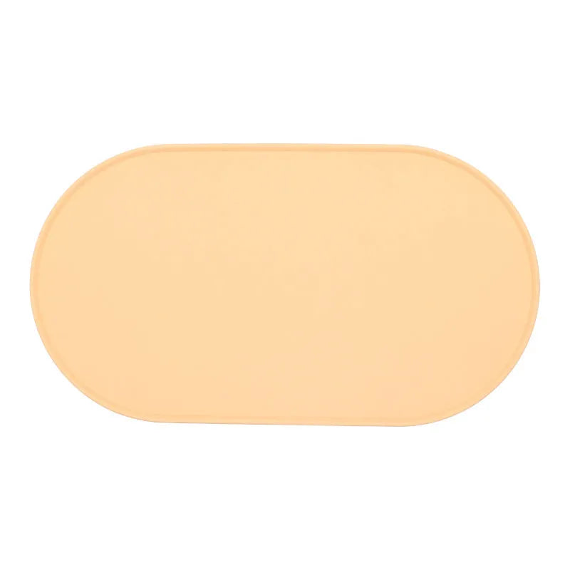 Silicone waterproof cat feeding placemat in beige colour on a wooden floor next to a pet bowl.