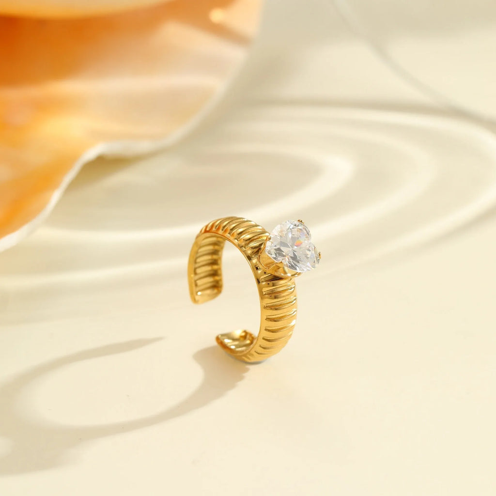 Gold-coloured stainless steel open ring with zircon stones in a geometric heart design.