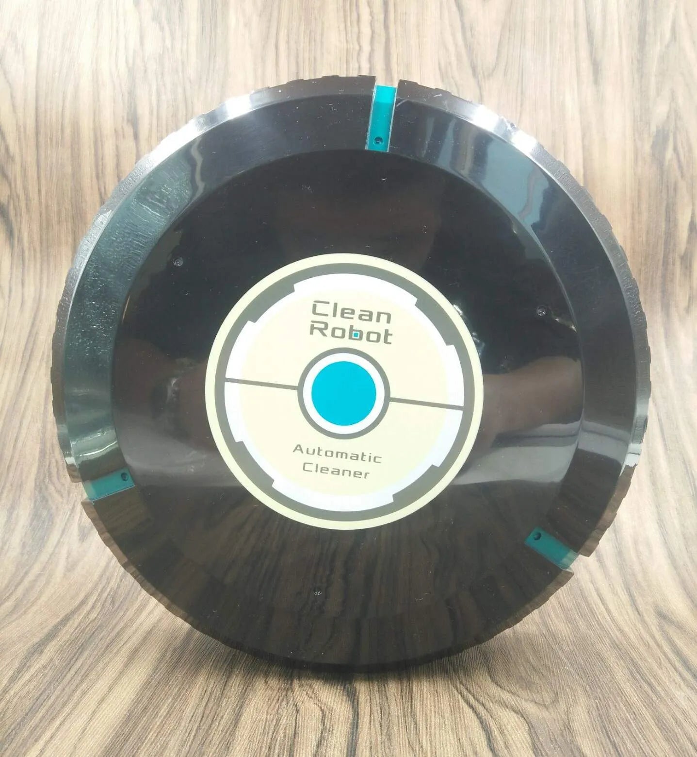 AC automatic sweeping robot on wooden floor with black ABS plastic body
