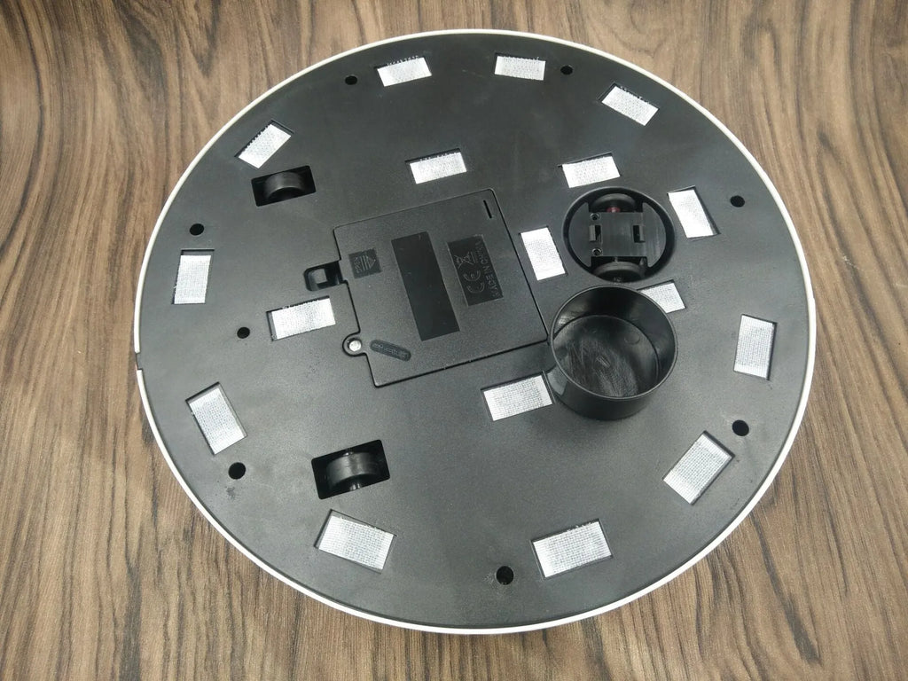 AC automatic sweeping robot on wooden floor with black ABS plastic body