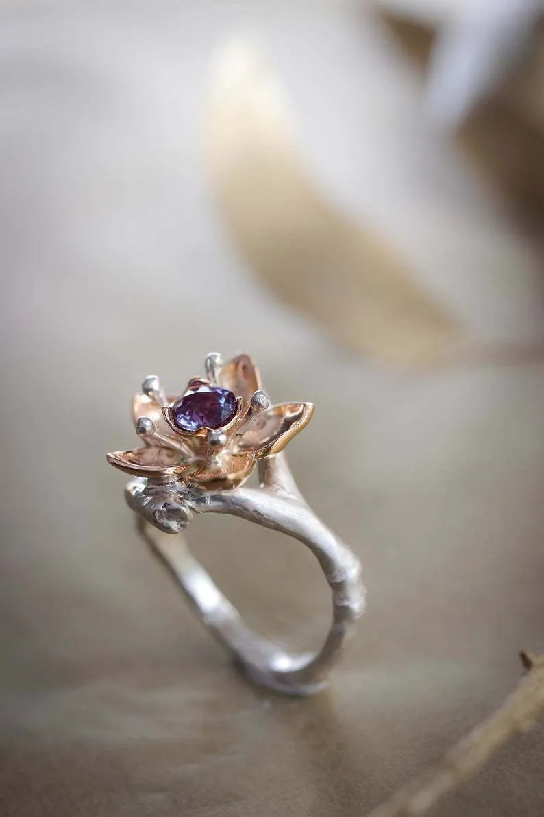 Silver-tone alloy women's ring with geometric shape and two-tone floral design on a white background.