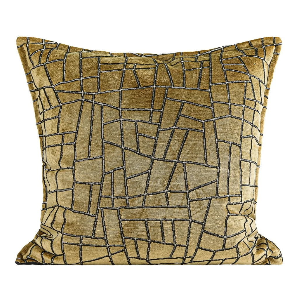 Geometric abstract pattern decorative pillow case in gold colour on a grey sofa.