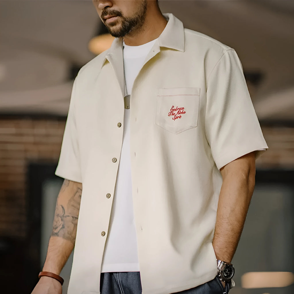 Light apricot men's shirt with bamboo plant pattern and Cuban collar on hanger