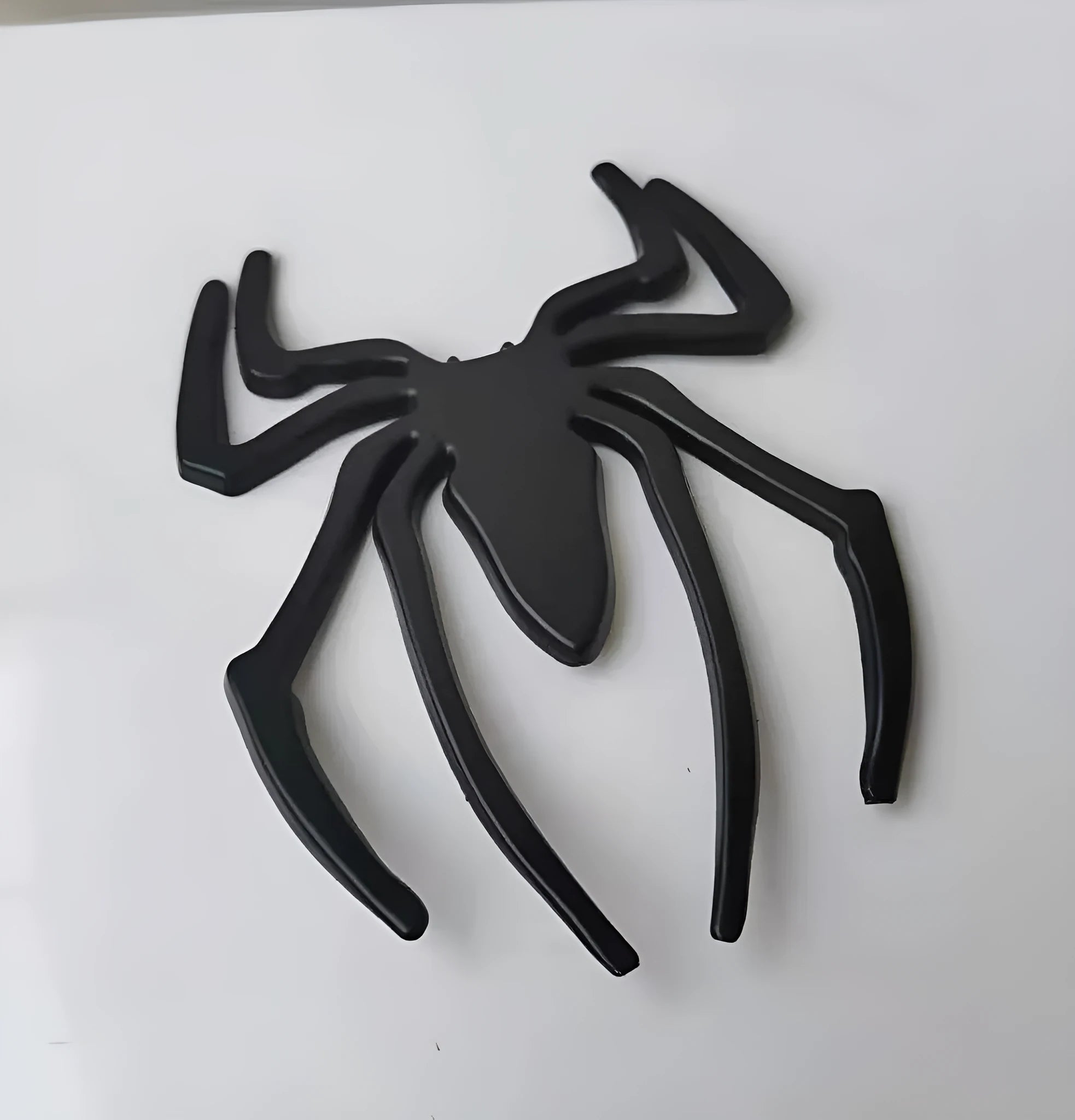 3D metallic spider bumper sticker in gold, silver, black, and red colour options.