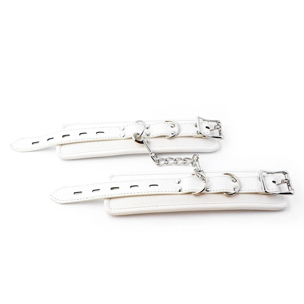 White PU sponge sex toy bondage kit showing handcuffs, foot cuffs, and a neck scarf arranged together.