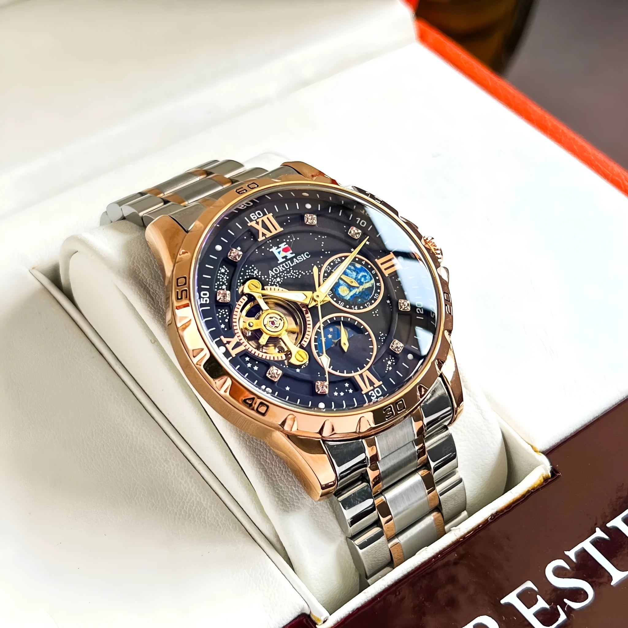 Men's rose gold automatic watch with large black dial on wrist.