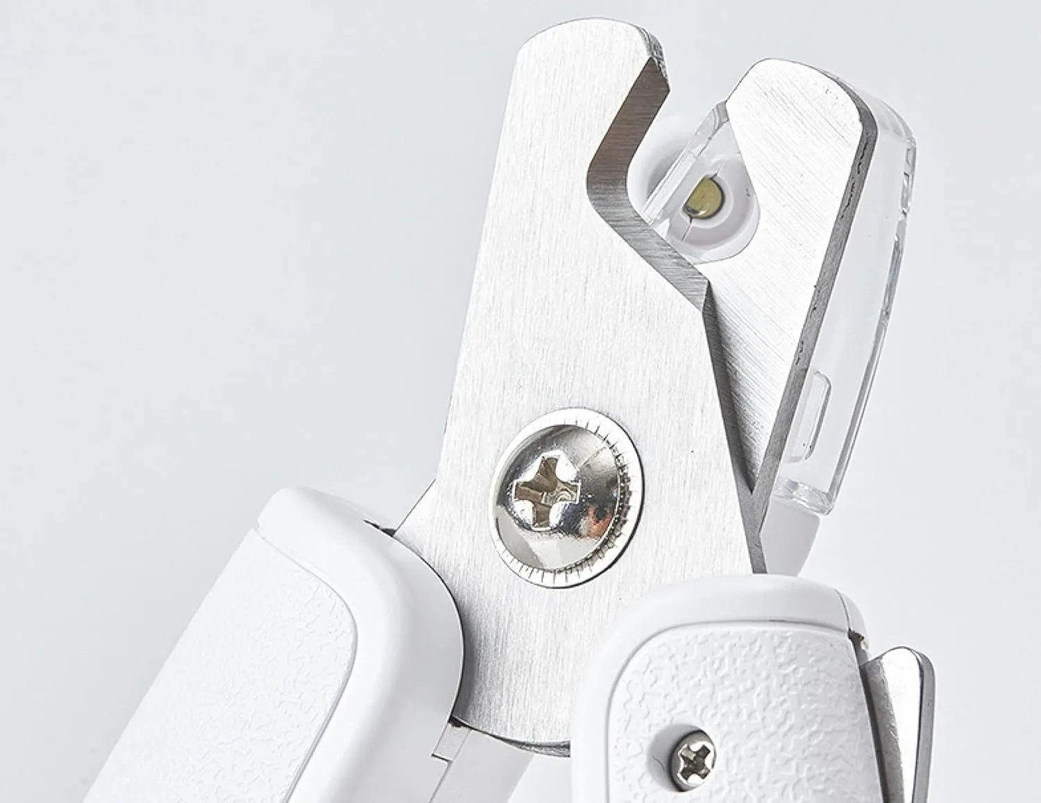White pet nail clippers with LED light, anti-splash guard, and built-in file on a grey surface
