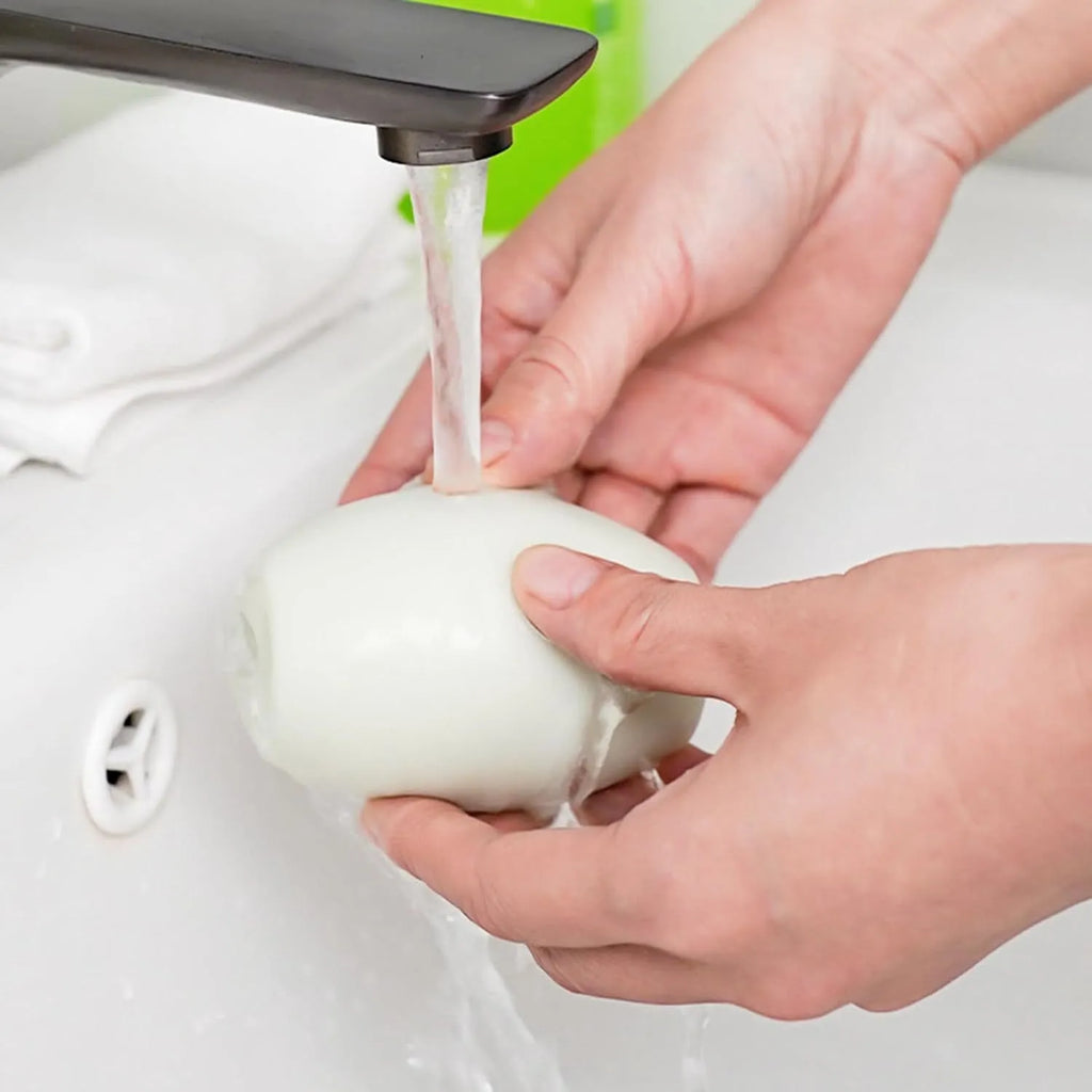Green and white reusable gel lint roller ball for pet hair removal from clothes and furniture