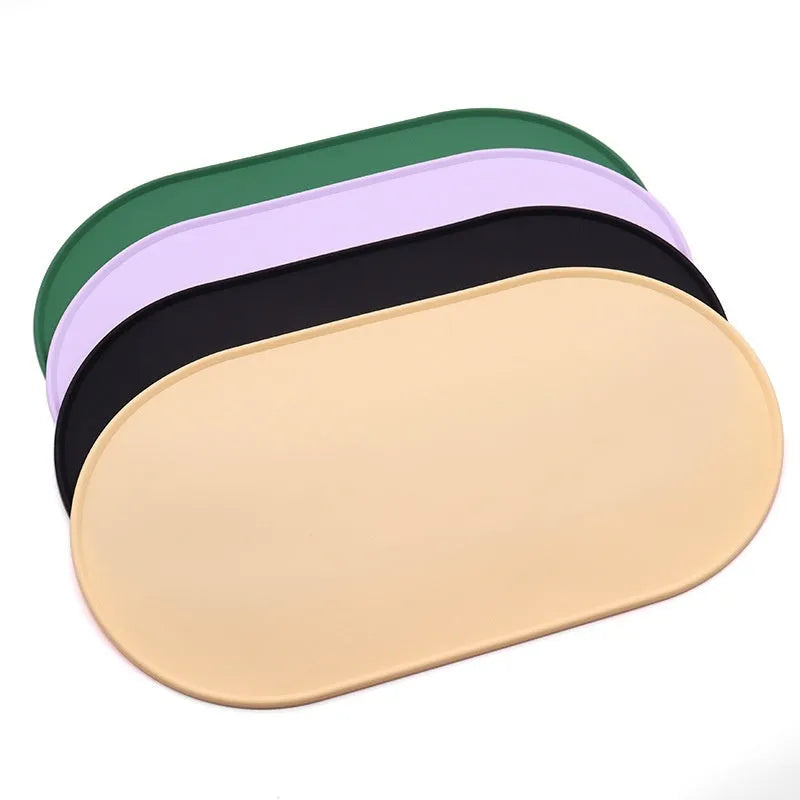 Silicone waterproof cat feeding placemat in beige colour on a wooden floor next to a pet bowl.