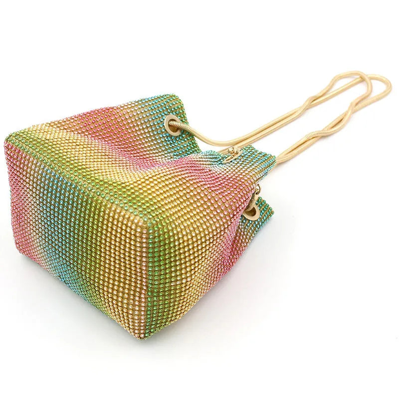 Rhinestone-decorated rainbow bucket bag with shoulder strap on a soft fabric base