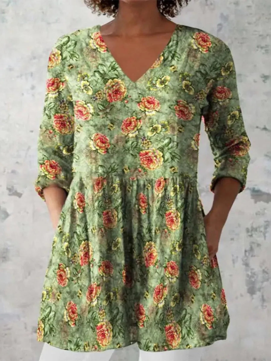 A woman wearing a printed, loose-fitting dress with a wide waist and three-quarter length sleeves.