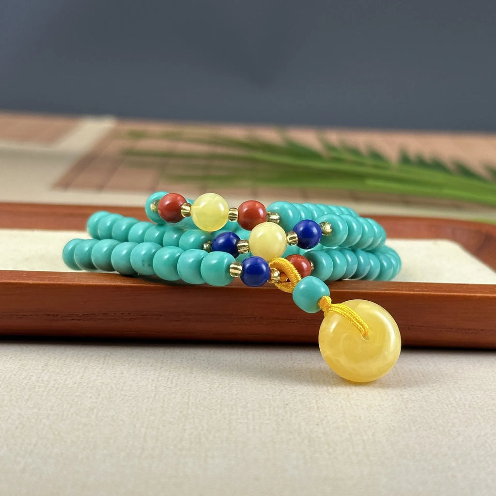 Turquoise stone pendant with hand-woven mesh flower design on a ball bead necklace chain.