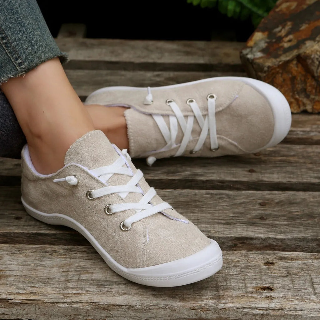 Women's creamy white low-top fabric sneakers with rubber soles on various surfaces