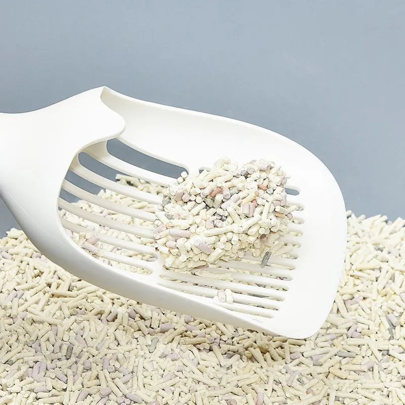 White plastic cat litter scoop with storage base on a clean surface