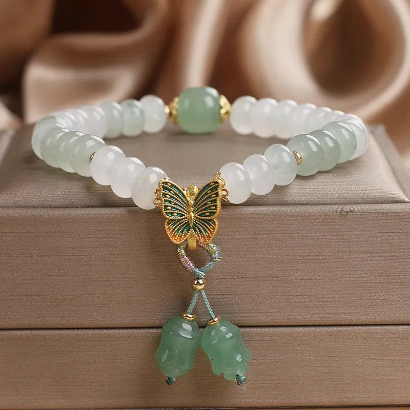 Green crystal abacus bead bracelet with retro butterfly tassel and pearl accents on a 17cm chain.