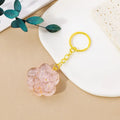 Natural crystal cat's paw shaped pendant on a silver keychain ring, shown in a random colour.