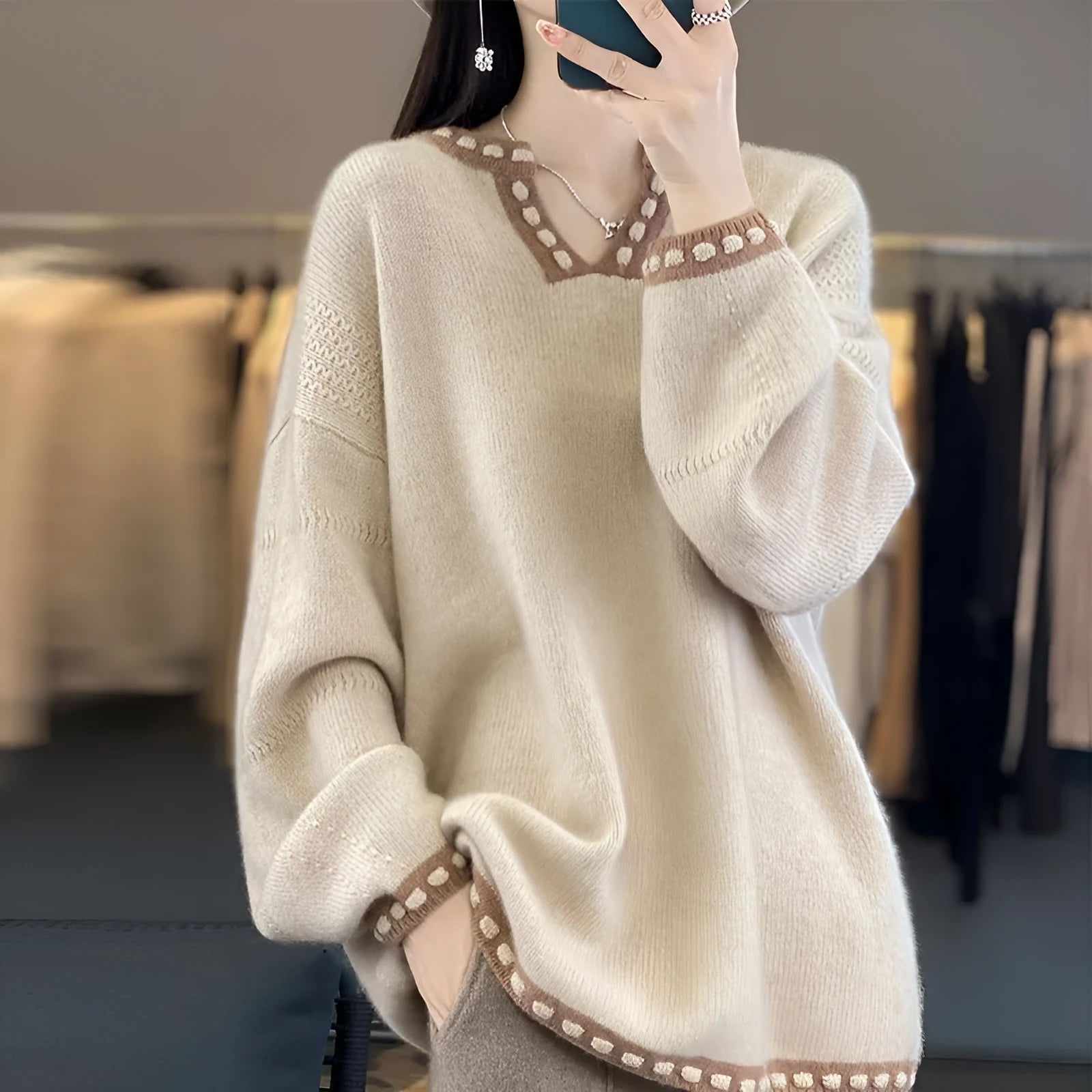 Women's camel coloured V-neck viscose pullover sweater with long sleeves on a hanger.