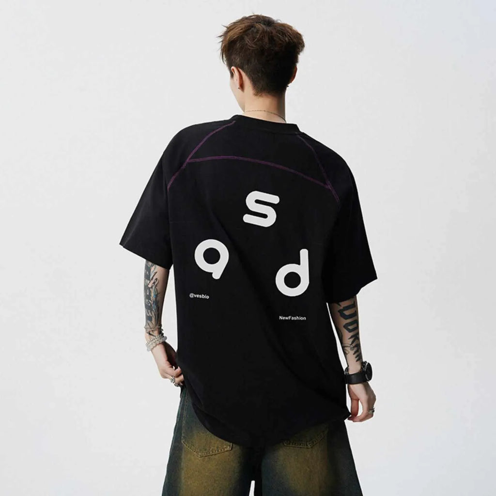 A loose-fitting black cotton short-sleeve T-shirt with a round neck on a hanger.
